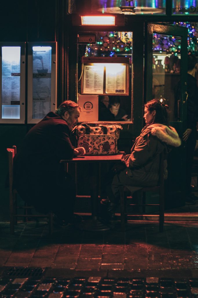 Man and woman talking in dim light after cheating in a relationship